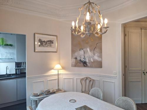 une salle à manger avec une table et un lustre dans l'établissement Plein Centre Charmant et Lumineux, à Paris