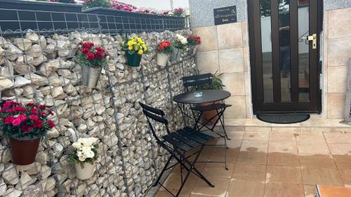 a stone wall with potted flowers and a table and chairs at Zum Sterngässchen in Ludwigshafen am Rhein
