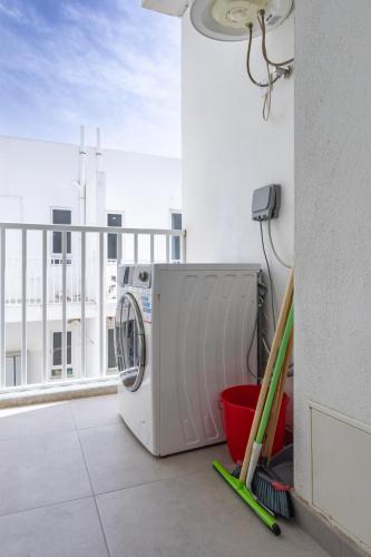 a washing machine on a balcony with a window at Sea View & Private Terrace Near Promenade -Sleep 8 by QuickTrips in St. Paul's Bay