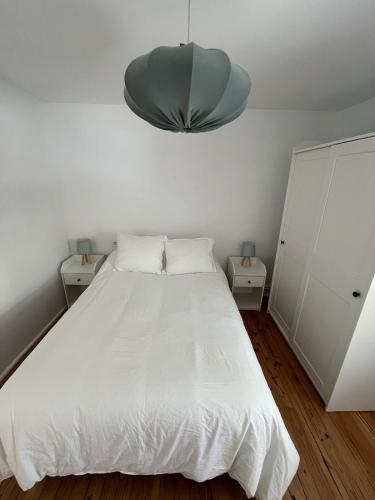 a bedroom with a white bed with two night stands at En una Casa Barata de La Mancha in Tomelloso