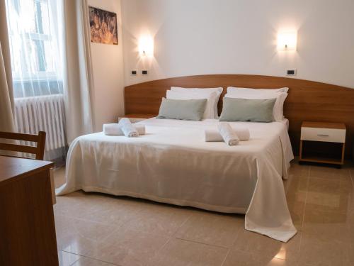 a bedroom with a large bed with white sheets and pillows at Hotel Ca' De Berna in Balestrino