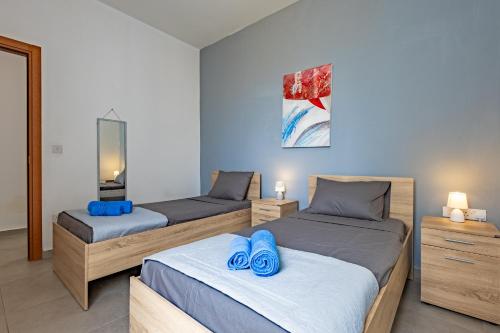 two beds in a room with blue towels on them at Sea View & Private Terrace Near Promenade -Sleep 8 by QuickTrips in St. Paul's Bay