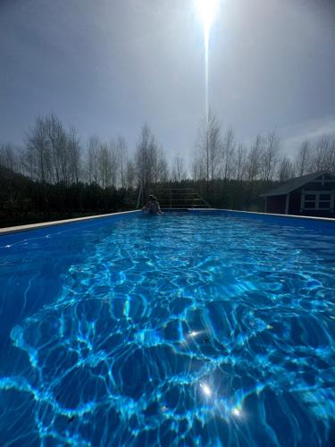 a person is sitting in a swimming pool at Szept Oberlandu - boutique, luxury Villa in Liva Park in Liwa
