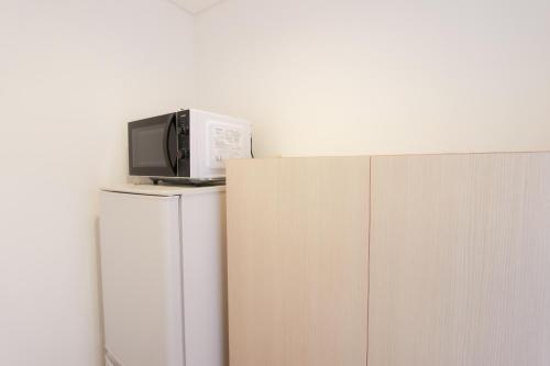 a microwave sitting on top of a refrigerator at HOTEL DO-YA Beppu in Beppu