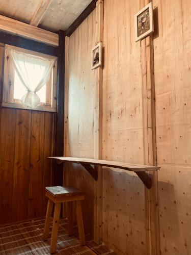 a room with a wooden wall with a table and a stool at maison Rose & Jardinier eco homestay in Sa Pa