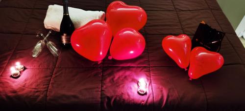 a group of red balloons on a bed with candles at dolce roma in Civitavecchia