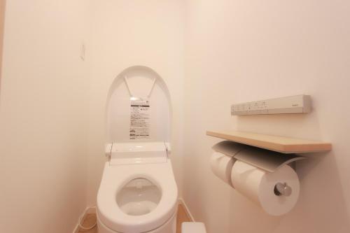a bathroom with a toilet with a sign on it at HOTEL DO-YA Beppu in Beppu