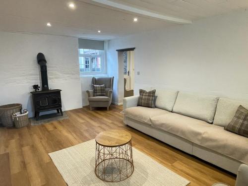 a living room with a couch and a wood stove at The Granary, Cilbronnau Farm, Cardigan in Llechryd