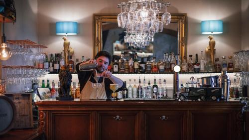 a man pouring a drink at a bar at Slottshotellet in Kalmar