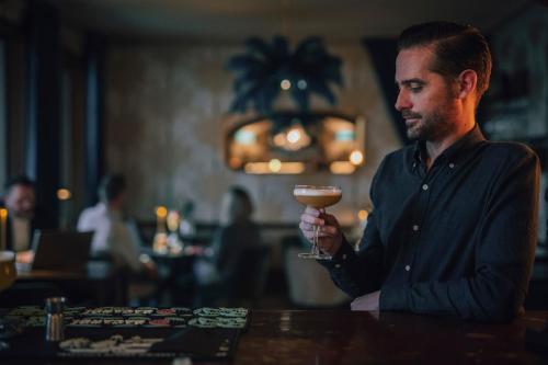 a man sitting at a bar holding a drink at Slottshotellet in Kalmar