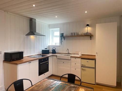 a kitchen with a sink and a stove at The Granary, Cilbronnau Farm, Cardigan in Llechryd