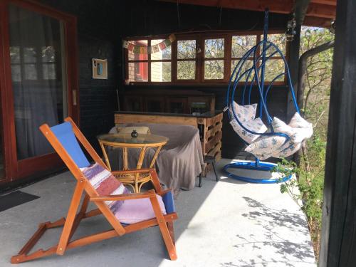 a porch with two chairs and a table and a hammock at Kokin Brod Apartments in Kokin Brod