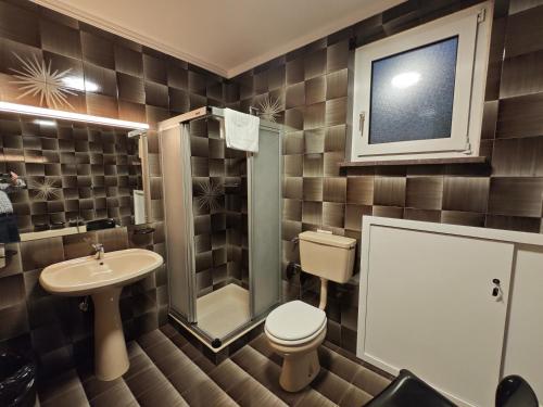 a bathroom with a toilet and a sink and a shower at Casa Rizzi in Campitello di Fassa