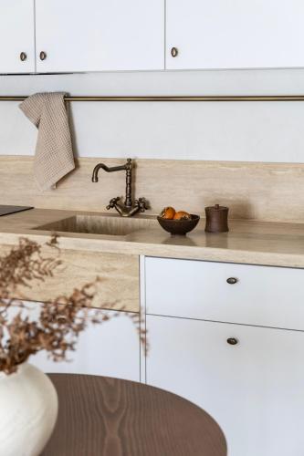 a kitchen counter with a sink and a bowl of fruit at Om Living Pelion in Agios Dimitrios