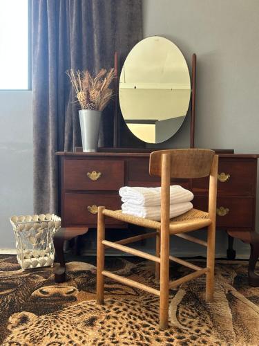 a chair in front of a dresser with a mirror at Riverside Sunday's in Colchester