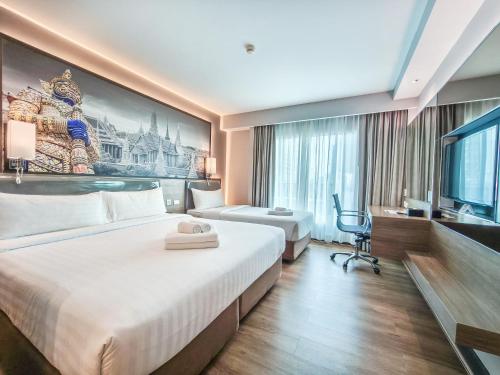 a hotel room with a large bed and a tv at Citrus Sukhumvit 11 by Compass Hospitality in Bangkok