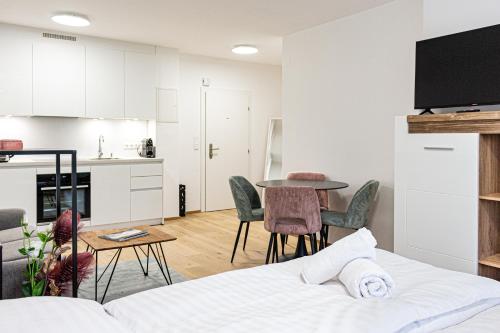 a living room and kitchen with a bed and a table at RIOpartment Ossiacher See in Bodensdorf