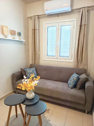 a living room with a couch and two tables at Elounda Solo Apartment in Elounda