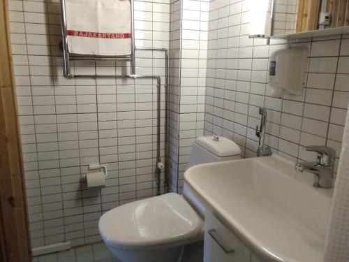 a white bathroom with a toilet and a sink at Hotelli Möhkön Rajakartano - Ilomantsi in Petkeljärvi