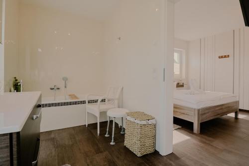 a white kitchen with a table and a bed at Villa Große Freiheit in Trent