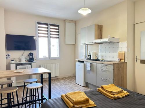 une cuisine avec une table et des chaises et une table et un comptoir dans l'établissement Studio proche centre et gare, à Parthenay