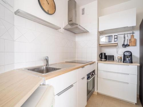 une cuisine blanche avec un évier et un micro-ondes dans l'établissement Le camas, à Marseille