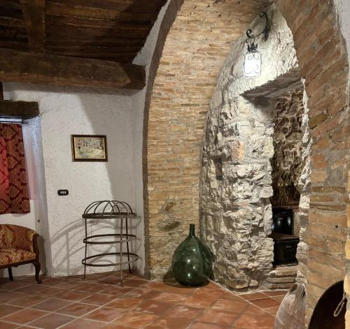 a room with a stone fireplace and a chair at Perbacco in SantʼAngelo Limosano