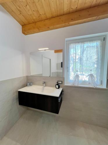 a bathroom with a sink and a window at Sogno Blu - Levico in Levico Terme