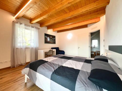 a bedroom with a bed and a wooden ceiling at Sogno Blu - Levico in Levico Terme