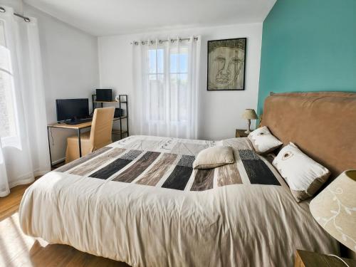 une chambre avec un grand lit et un bureau dans l'établissement Appartement cosy près Disney, jardin & terrasse, à Magny-le-Hongre