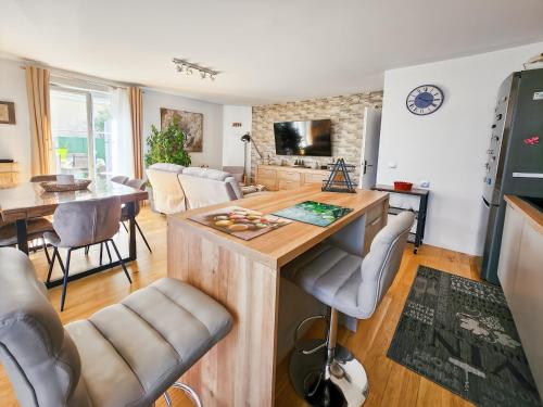 une cuisine et un salon avec une table et des chaises dans l'établissement Appartement cosy près Disney, jardin & terrasse, à Magny-le-Hongre