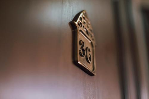 a metal door knob on a door with the number thirtysix at Slottshotellet in Kalmar
