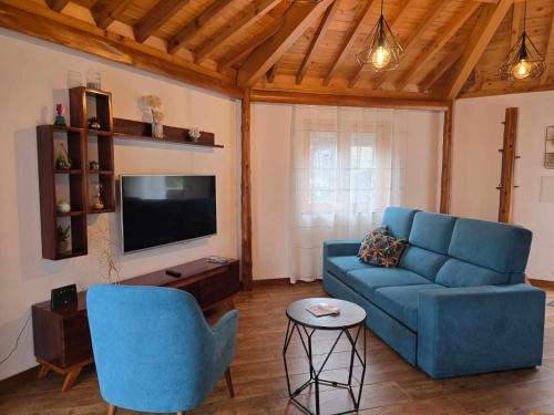 a living room with a blue couch and a tv at Adega Mendes in Porto Martins