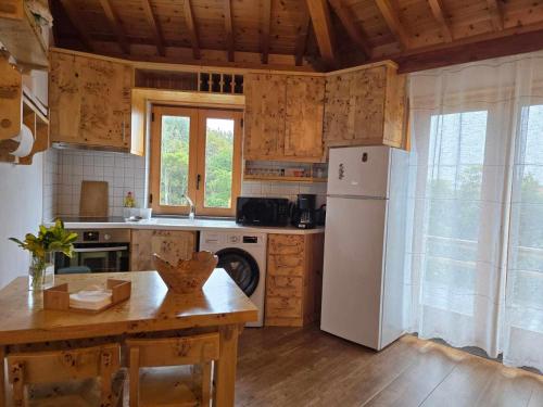 a kitchen with a white refrigerator and a table at Adega Mendes in Porto Martins