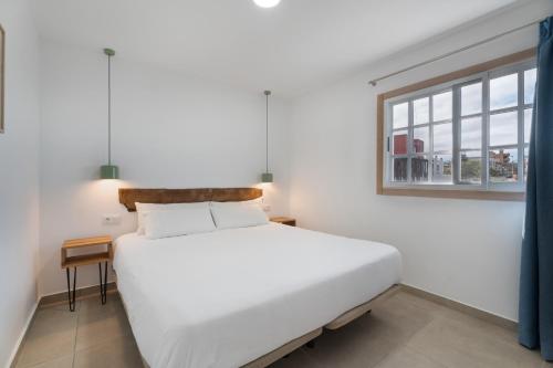 a white bed in a room with a window at El Rincón House Tenerife Tijoco in Adeje