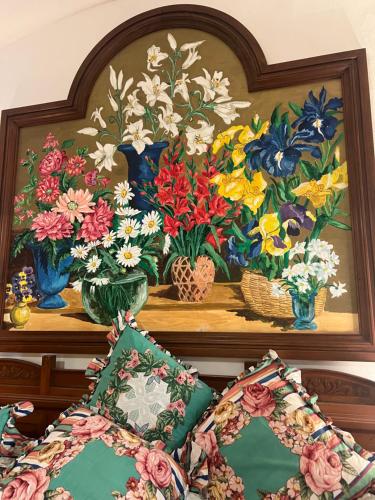 a painting of flowers in vases on a shelf at Casa Bacot in Canneto