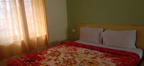 a bed with a red blanket and white pillows at Stay awhile in Ooty