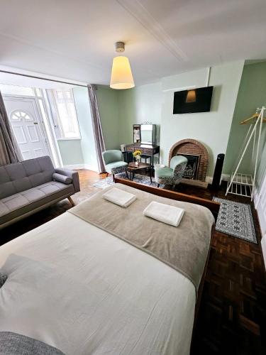 a bedroom with a bed and a living room with a fireplace at A-N-G Apartments - Parking EV 22kW by the Beach, Canoe Lake & South Parade Pier in Portsmouth