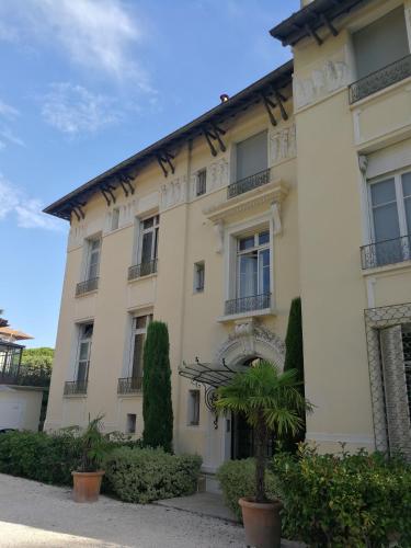 un bâtiment avec un palmier devant dans l'établissement CANNES Vue Mer & Balcon dans Villa Exceptionnelle Belle Époque la Californie, à Cannes