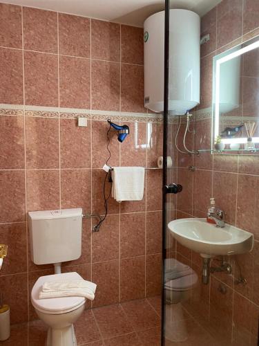 a bathroom with a toilet and a sink at 4 You Apartments in Mugeba