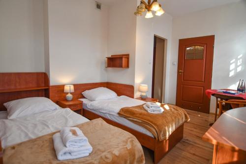 a hotel room with two beds and a table at Willa Dąbrówka in Szczawno-Zdrój