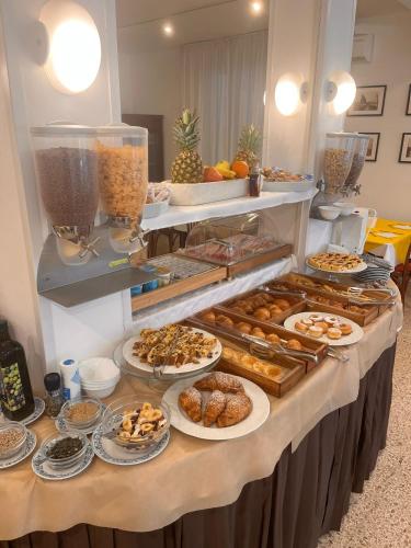 Un buffet con muchos tipos diferentes de pasteles y postres. en Hotel Lucciola, en Cattolica