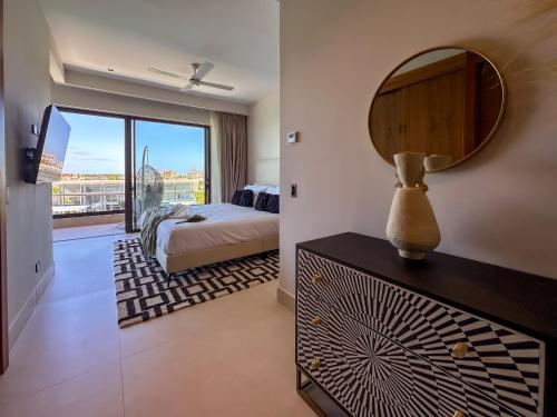 a bedroom with a bed and a mirror at Marina Garden Cap Cana by Beach Homes Punta Cana in Punta Cana