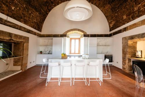 una cocina con una gran mesa blanca y sillas en Visitsicilia Torre Marausa, en Marausa