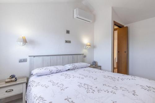 a bedroom with a white bed and two night stands at Charlotte Apartment - For family and groups in Porto Torres