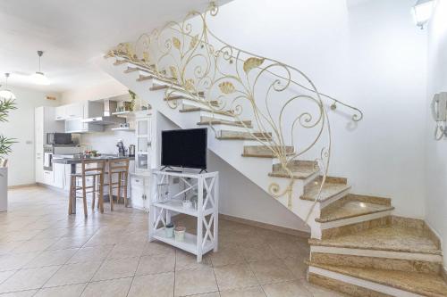 a staircase in a living room with a tv and a kitchen at Charlotte Apartment - For family and groups in Porto Torres