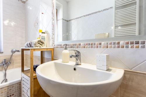 a bathroom with a sink and a bath tub at Charlotte Apartment - For family and groups in Porto Torres