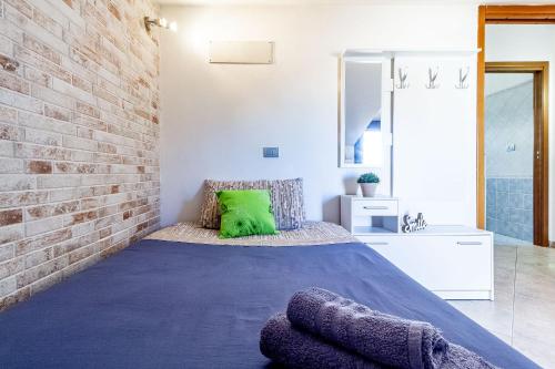 a bedroom with a bed and a brick wall at Charlotte Apartment - For family and groups in Porto Torres