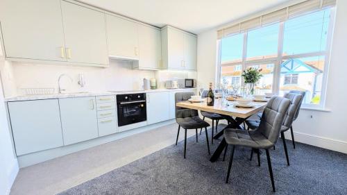 a kitchen with a table and chairs in a room at Llandudno Lounge by Seaside Llandudno in Llandudno