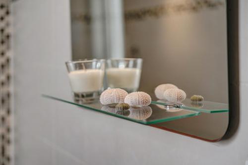 a glass table with two glasses of milk and some muffins at Sweet Family House in Cala d´Or